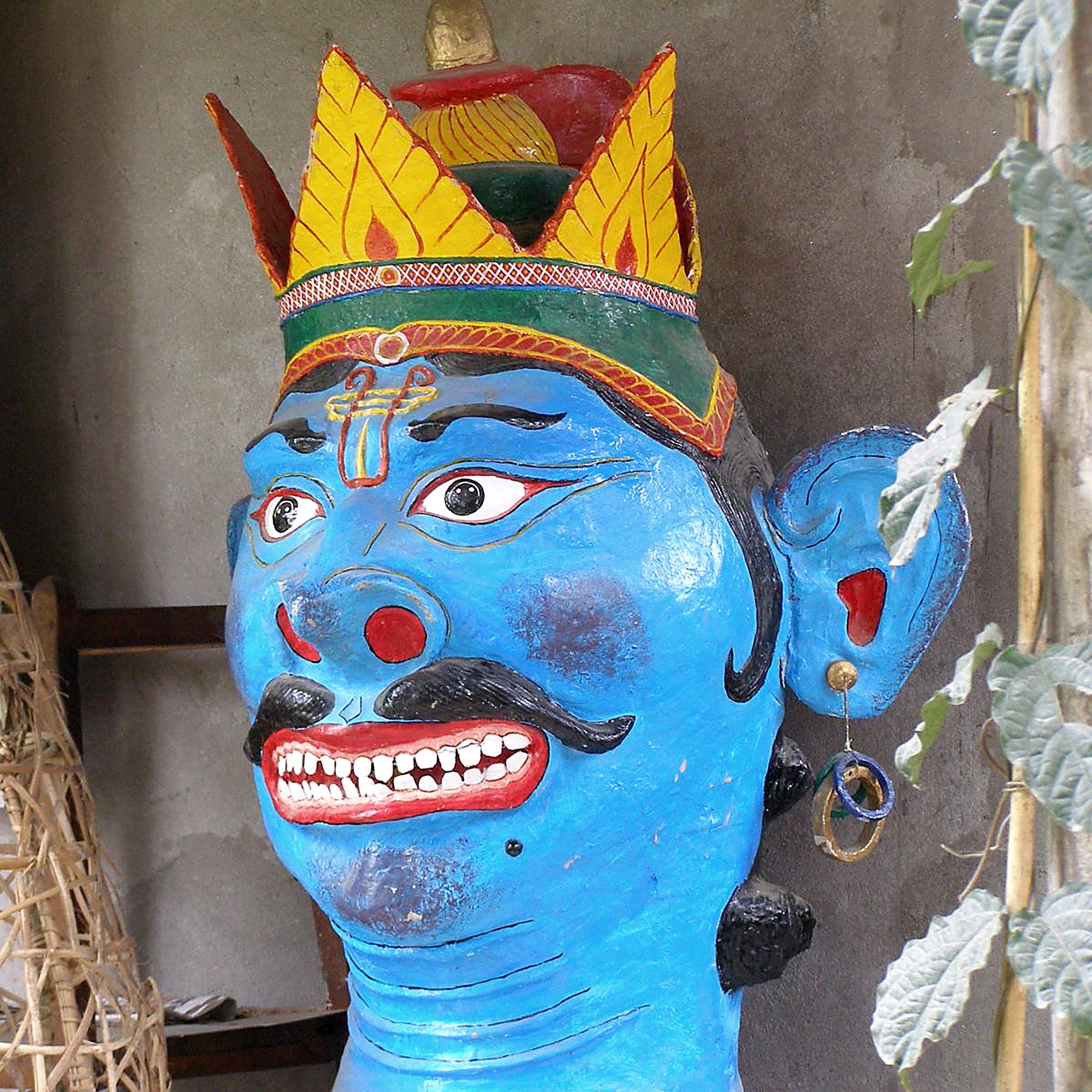 Hand-painted blue Ravana mask with a golden crown, crafted for a traditional Assamese performance